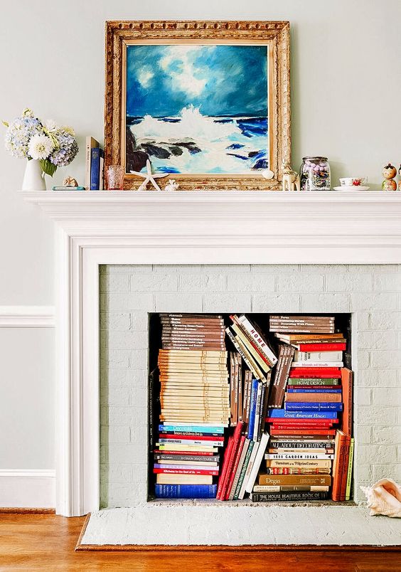 A non working fireplace with magazines and books inside is a cool idea for storage, these books also add some color