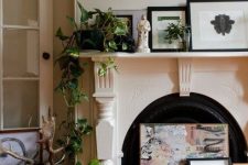 a vintage fireplace with an arrangement of artworks, with potted plants and a statue is a beautiful idea for a refined feel