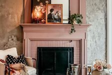 a vintage living room with a fireplace and a dusty pink mantel, a white chair and sofa, a coffee table styled for a tea party