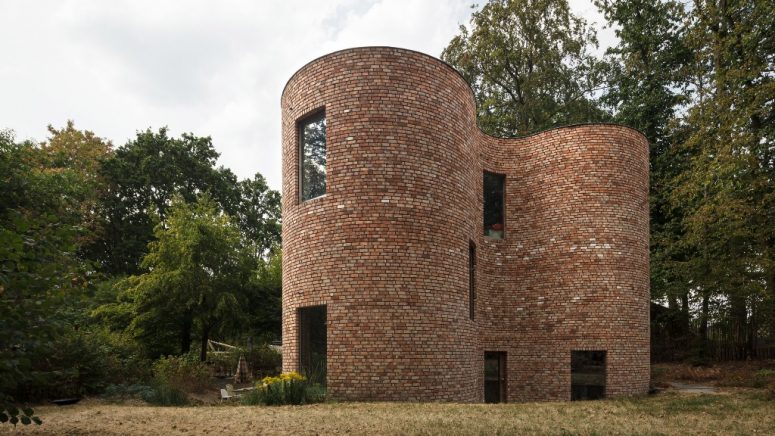 This unique house in Belgium is built of reclaimed bricks and is dotted with large windows here and there also featuring a gorgeous shape