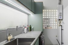 02 The laundry features sleek green cabinets and concrete countertops just like the kitchen