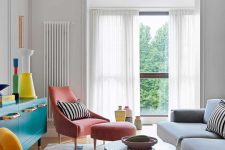 02 The living room features colorful furniture and objects, striped accents and bold accessories