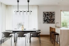03 The kitchen and dining space are united into one layout, with chic furniture, quirky art and bold lamps