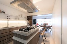 03 The kitchen shows off wooden cabinets and white stone countertops, with built-in lights and sliding panels that can be opened or closed