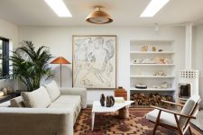 04 The living room is stylish and calming, with a bold artwork and a statement plant