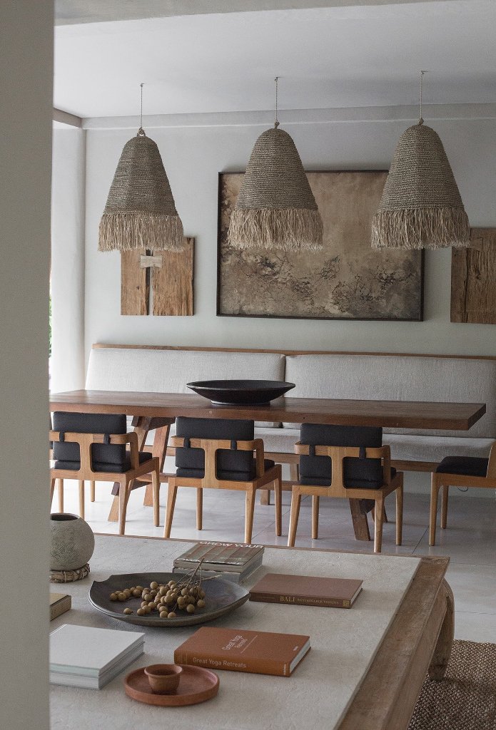 The dining space is done with comofrtable chairs, woven pendant lamps and pieces of the house hung as a gallery wall