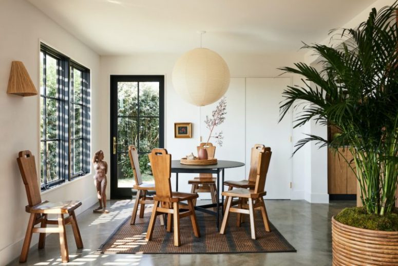 The dining space is maked with a geometric table and vintage wooden chairs