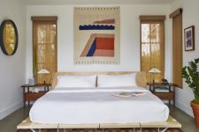 08 The master bedroom is done with bold touches, comfortable mid-century modern furniture and burlap shades
