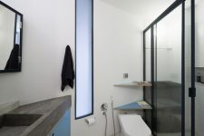 10 The bathroom is small, done in grey, white and blue with concrete countertops and a comfy shower