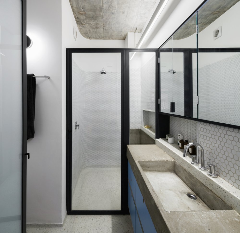 White penny tiles paired with concrete and sleek blue surfaces make the space bold
