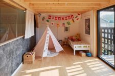 12 The kid’s room features a bed, a teepee, some bold art and garlands and an entrance to the balcony