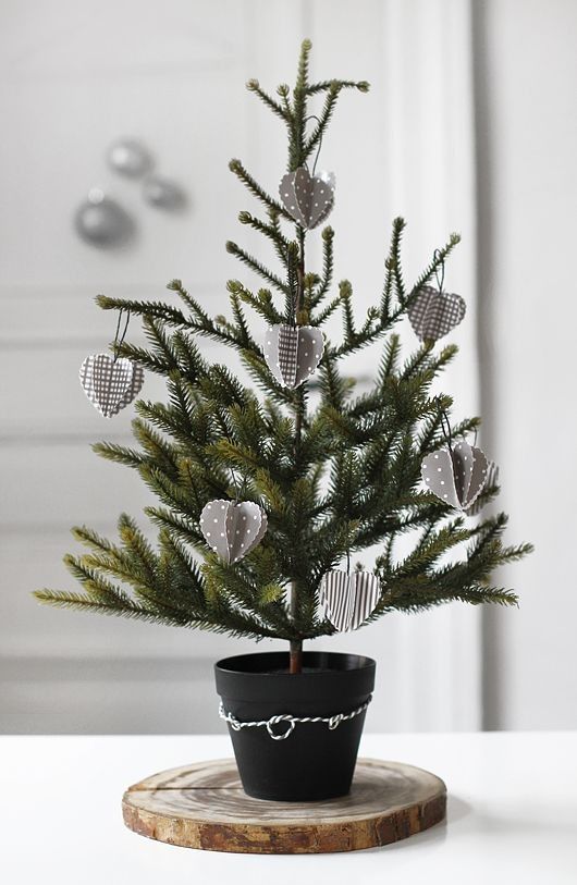 A Nordic tabletop Christmas tree in a pot decorated with grey and white 3D cardboard ornaments is a pretty and eco friendly idea