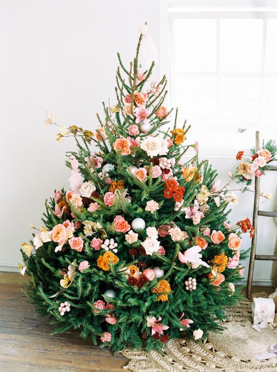 a beautiful Christmas tree with orange, rust, burgundy, blush and pink blooms, some branches and leaves is a very cute and romantic idea