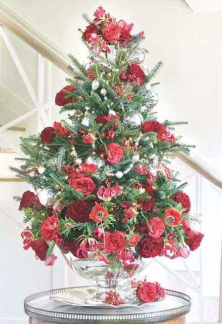 a beautiful tabletop Christmas tree with greenery, red and burgundy fresh flowers plus some silver ornaments is an elegant idea