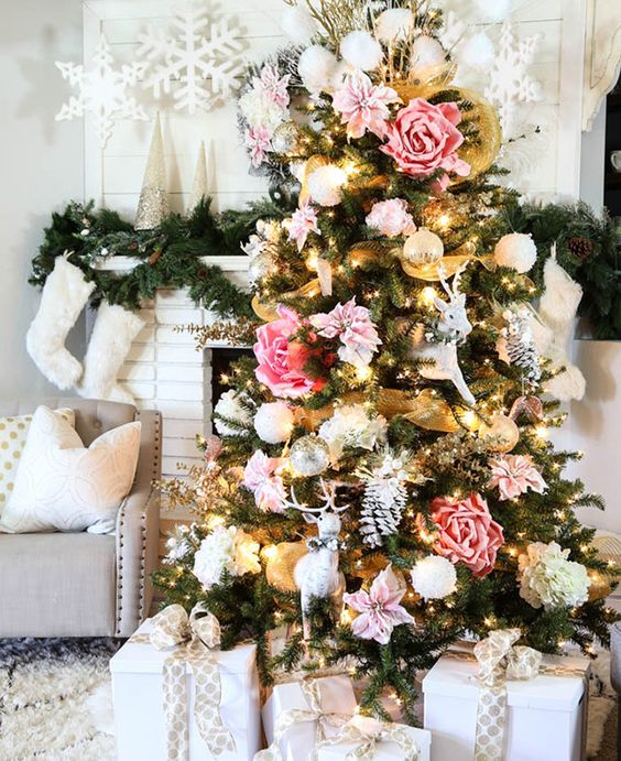 a glam Christmas tree decorated with blush and pink faux blooms, white snowballs and deer plus some lights