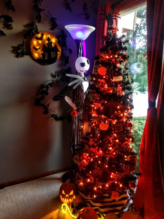 a gorgeous black Christmas tree with orange lights, pumpkins, Nightmare Before Christmas ornaments and a Jack Skellington figurine next to it