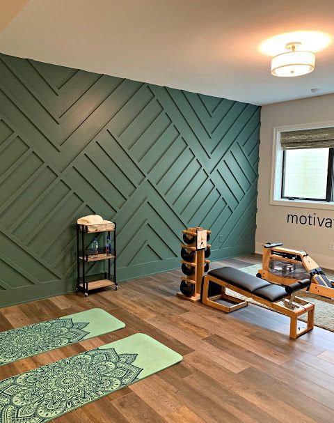 a home gym done with a green geometric paneled wall as a statement and all the rest of decor around it