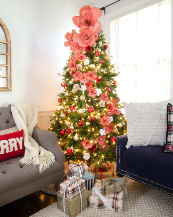 a lovely Christmas tree with silver and red ornaments, pink and white faux flowers of various sizes is beauty and chic