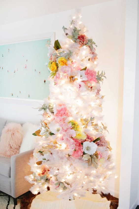 a lovely white Christmas tree with white, pink, yellow blooms, pale greenery and lights is an ethereal and chic idea to rock