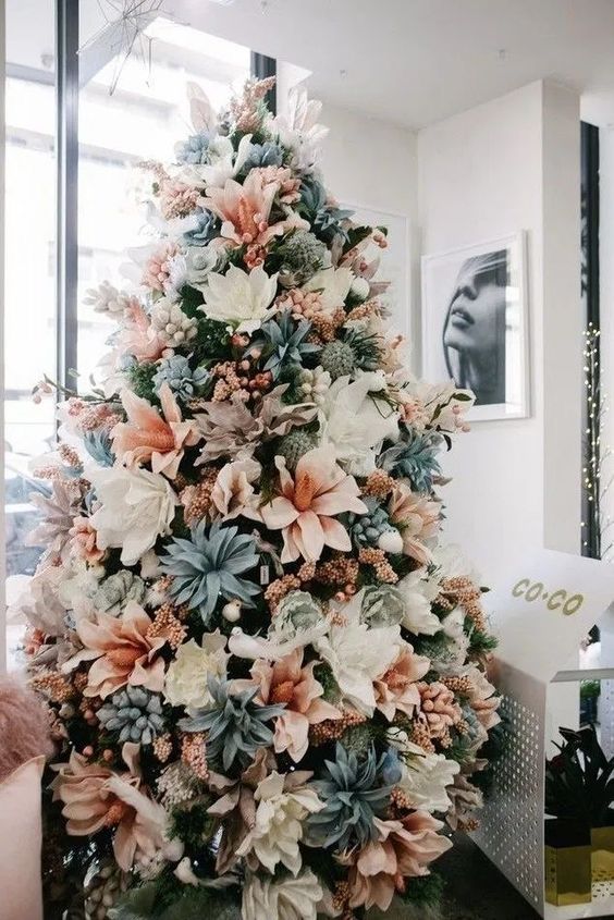 a pastel Christmas tree with white, blush, pale blue fabruc blooms and some pink garlands is a unique idea to go for