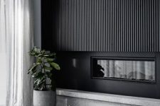 a sleek black wood slat wall with a built-in fireplace is a bold statement that will bring a dramatic touch to the space