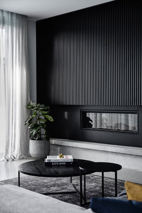 A sleek black wood slat wall with a built in fireplace is a bold statement that will bring a dramatic touch to the space