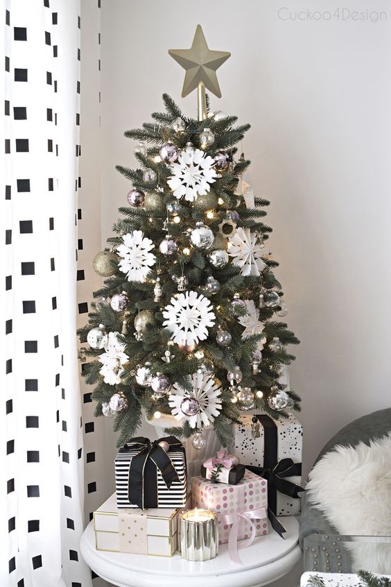 a stylish monochromatic Christmas tree with silver and gold ornaments, white snowflakes and lights plus a star topper