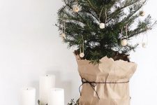 a tabletop Christmas tree decorated with wooden beads and wrapped with paper is a pretty idea with a Nordic feel