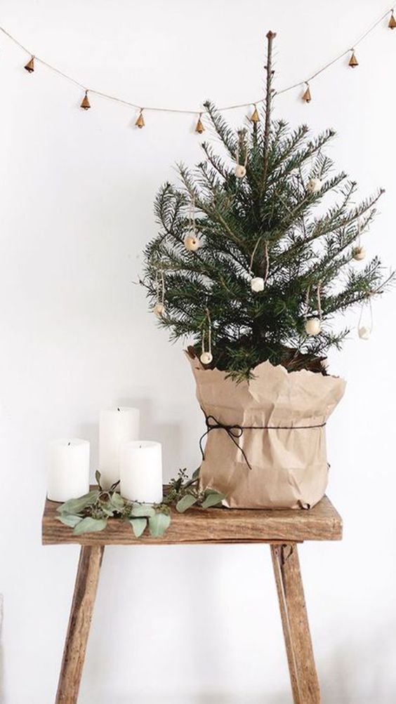 a tabletop Christmas tree decorated with wooden beads and wrapped with paper is a pretty idea with a Nordic feel