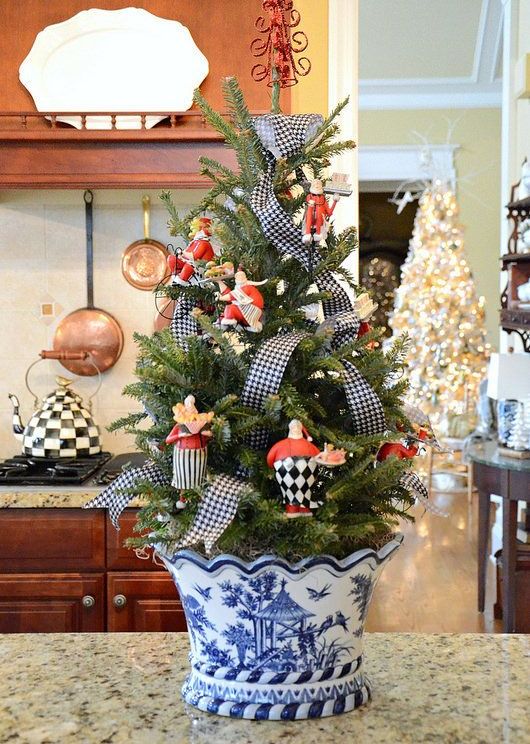 a tabletop Christmas tree in a chinoiserie planter, decorated with printed ribbons and vintage toys is a lovely and cool idea