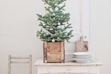 a tabletop Christmas tree in a wooden box and with pastel color block otnaments feels a bit retro and a bit rustic