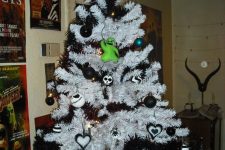 a white Christmas tree with black garlands, black and white ornaments, Jack Skellington ones and a Jack Skellinton topper