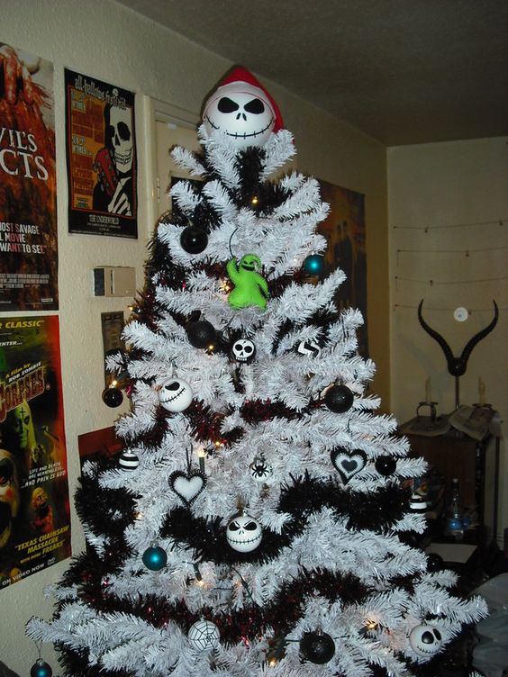 a white Christmas tree with black garlands, black and white ornaments, Jack Skellington ones and a Jack Skellinton topper