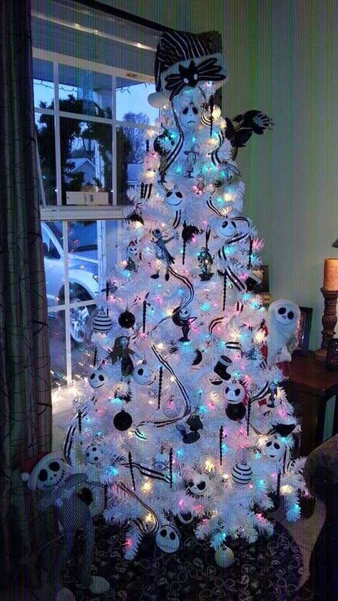 a white Christmas tree with colorful lights, black and white ribbons and ornaments, Jack Skellington ones, bows and garlands