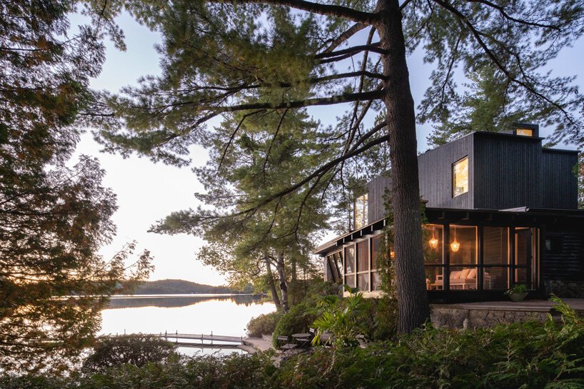 This rustic log cabin in Canada got an extension on top, it is clad with black timber to merge with nature