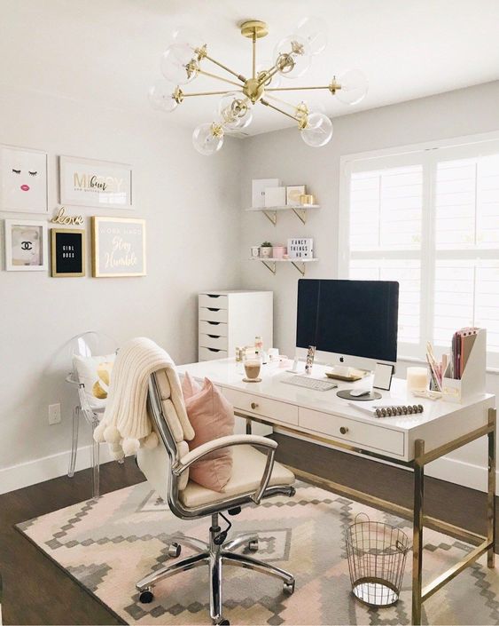 a glam and chic home office with gold touches and a comfy chair plus a cool girlish gallery wall