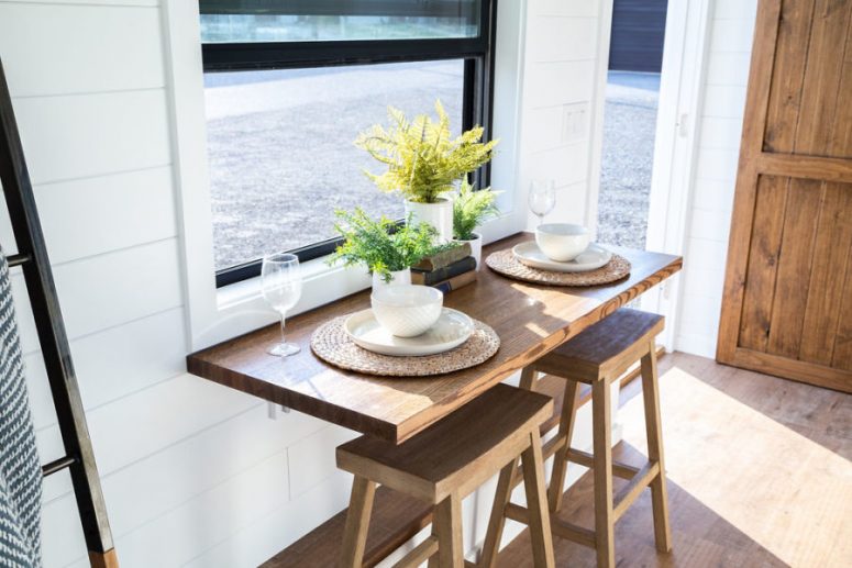 The dining space is done with a gold-down table and stools, the table is next to the window