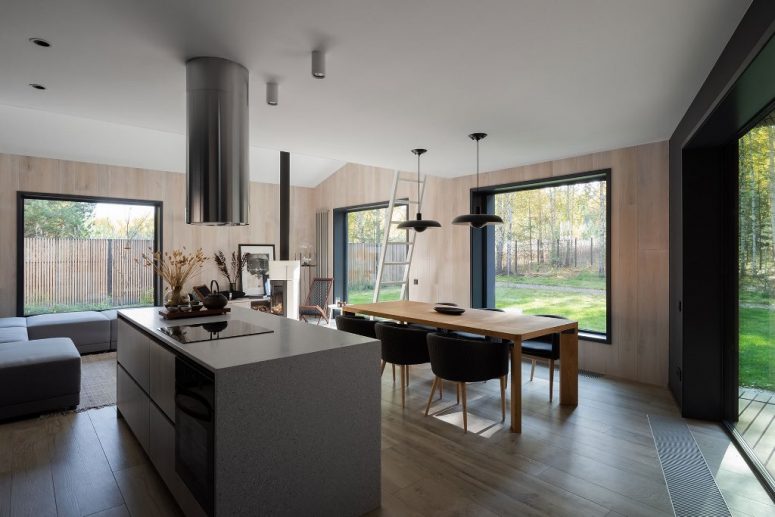 The main space is comprised of three parts - a kitchen, a dining room and a sitting zone, with stylish minimalist furniture and gorgeous unbstructed views
