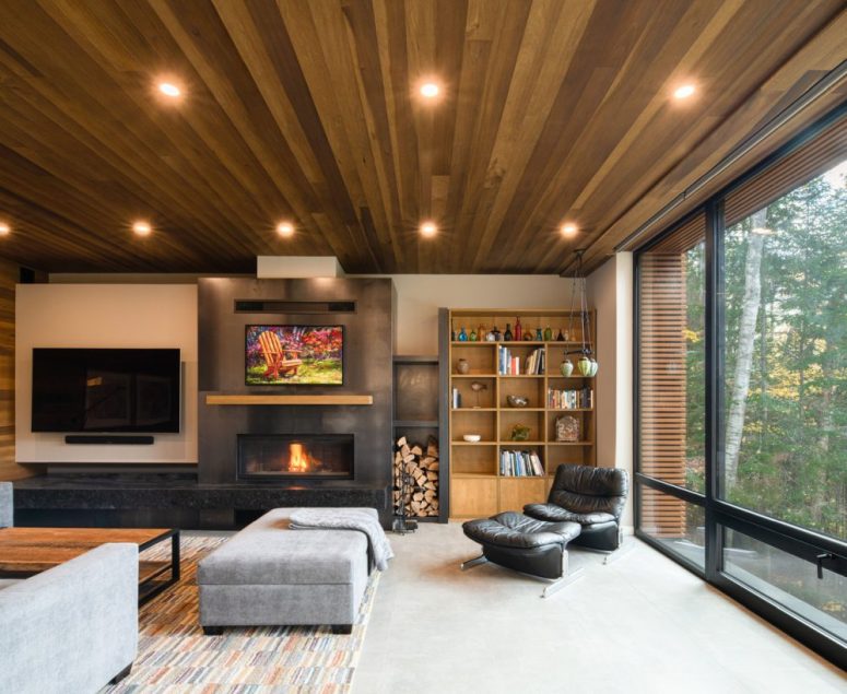 The living room shows off a built-in fireplace, upholstered and leather furniture, lights and a bright rug