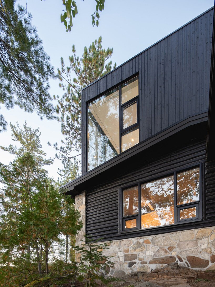 The old rustic log cabin was extended with a more modern part clad with black timber to match