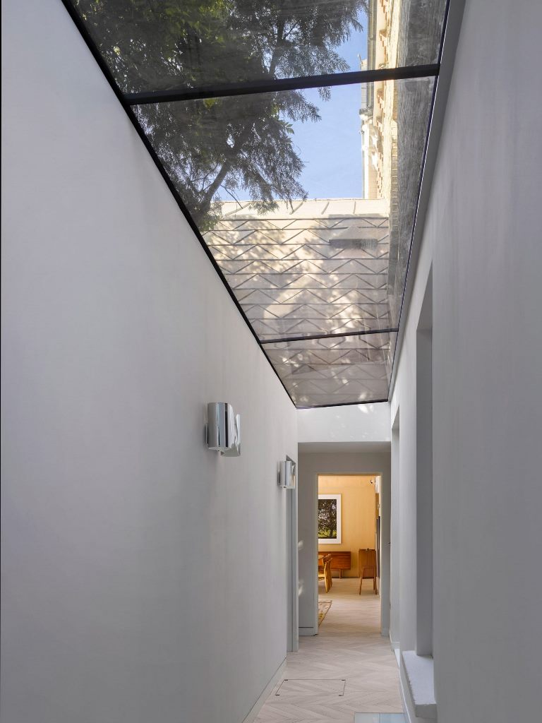 A glass roofed corridor links the extension with the front of the house