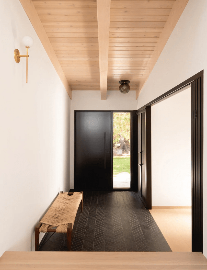 12 The entryway is simple and modern, clad with dark tiles and with a woven bench