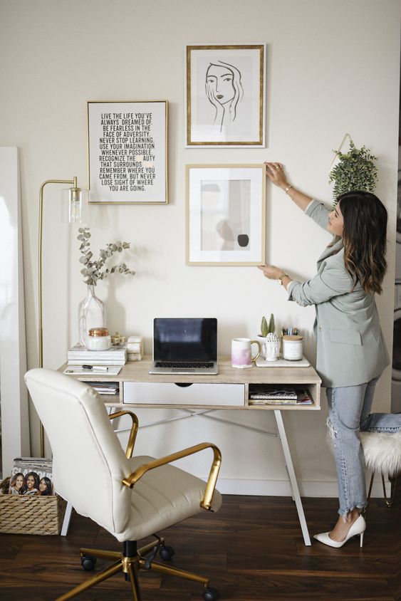 a neutral home office personalized with a gallery wall and with some greenery around