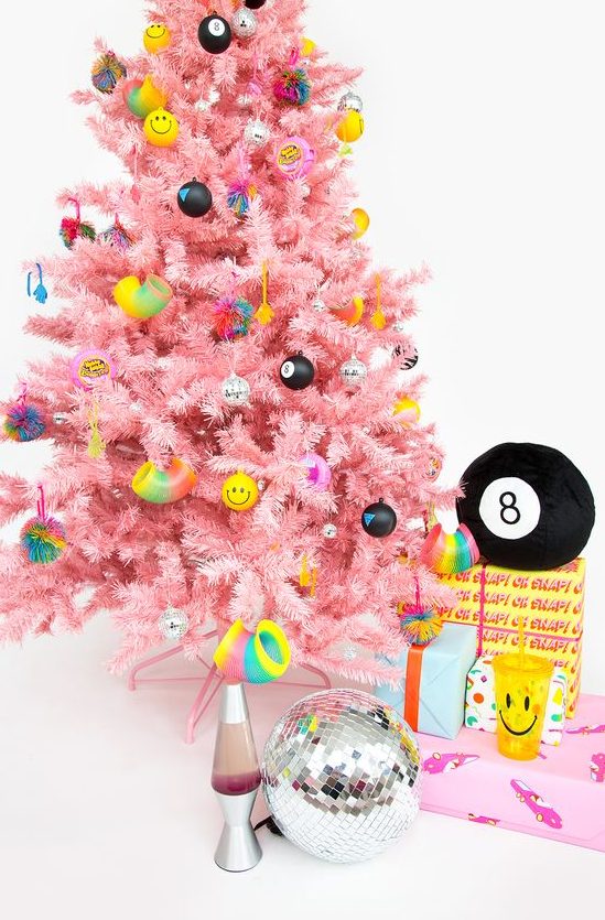 a bright pink Christmas tree with funny and colorful modern ornaments looks fresh and very bold