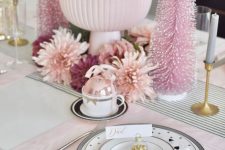 a glam pink Christmas table setting with pink and printed tiles, a pink ornament centerpiece, bottlebrush trees and blooms