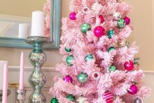 a pastel pink Christmas tree decorated with hot pink and green ornaments is a stylish vintage decor idea