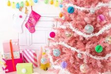 a pastel pink Christmas tree with colorful paper and glass Christmas ornaments and white garlands is a colorful modern solution