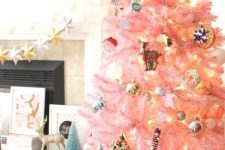 a pastel pink Christmas tree with metallic ornaments, lights and retro ones looks as a cute and chic touch of color