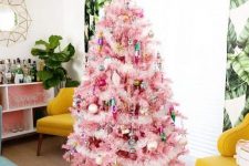 a pink Christmas tree with colorful ornaments and lights, with gold touches looks pretty and very chic