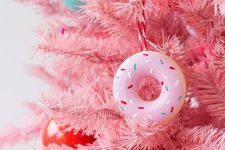 a pink Christmas tree with colorful ornaments and pink donut ornaments is a fun and cool idea for a glam space